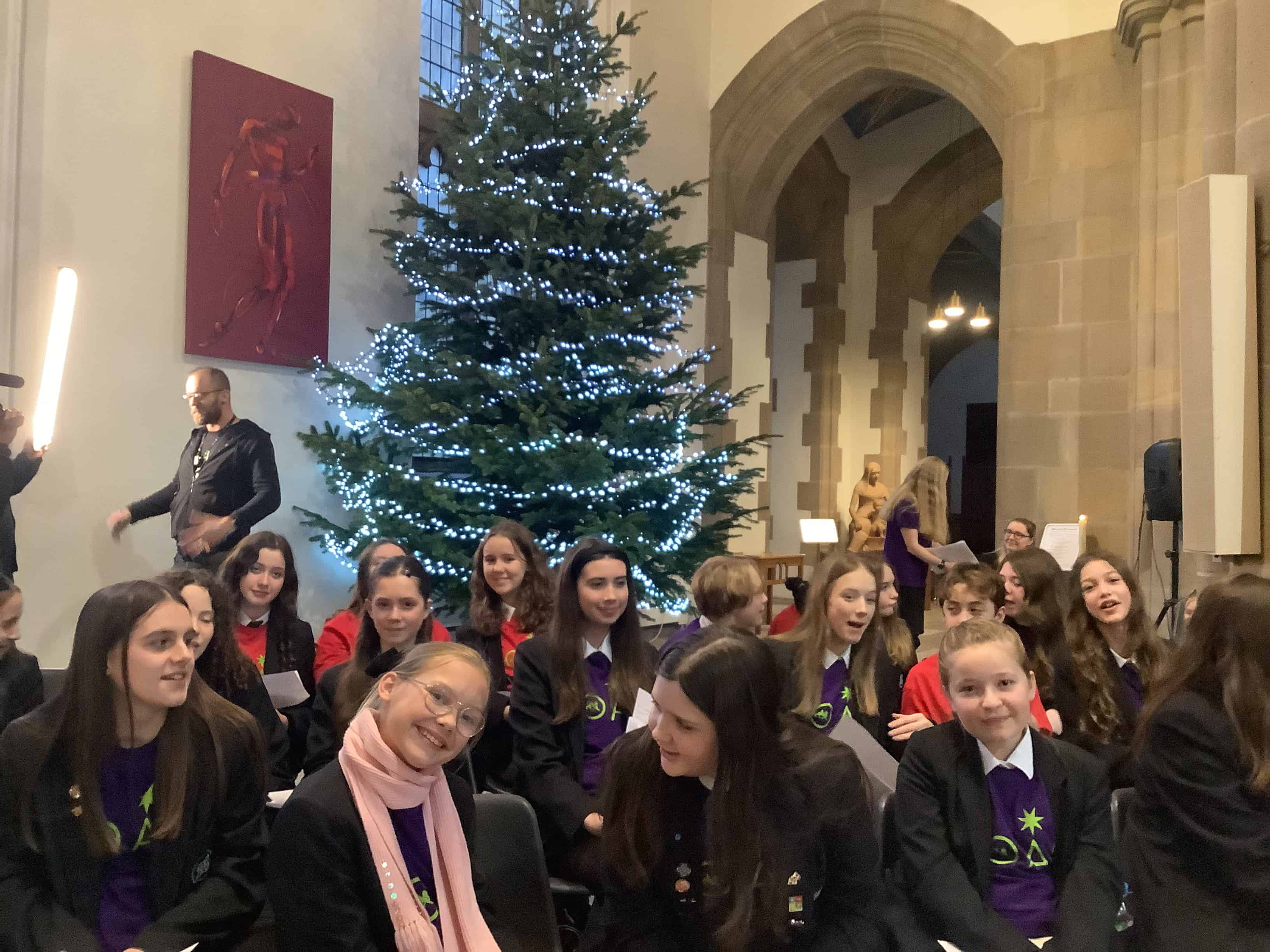 Children smiling infront of christmas tree