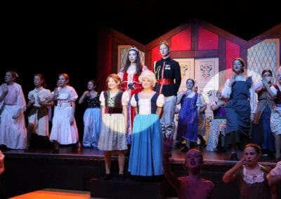 A spotlight shines on four students as they sing on stage in the Priestnall School Frozen Jr Production.