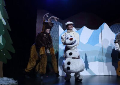 Students acting as Olaf and a reindeer smile on stage in the Priestnall School Frozen Jr Production.