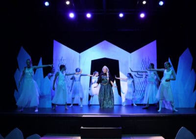 Elsa sings in centre of stage as other students perform choreography around her in the Priestnall School Frozen Jr Production.