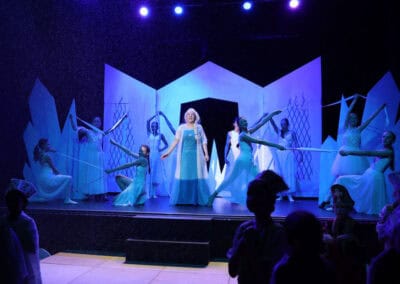 Elsa sings in centre of stage as other students perform choreography around her in the Priestnall School Frozen Jr Production.